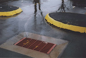 water with oil flowing into storm drain