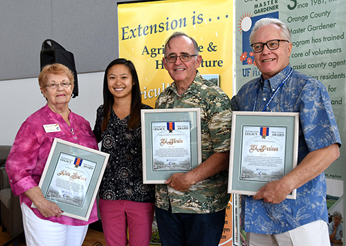 Photo of the award winners holding framed certificates and standing with Amy Vu